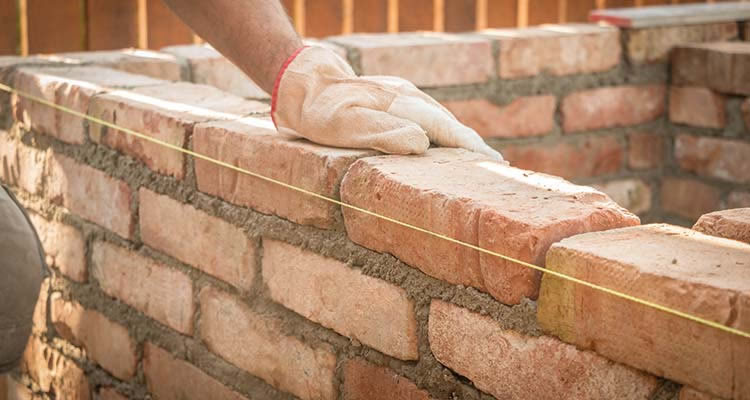 person building a brick wall
