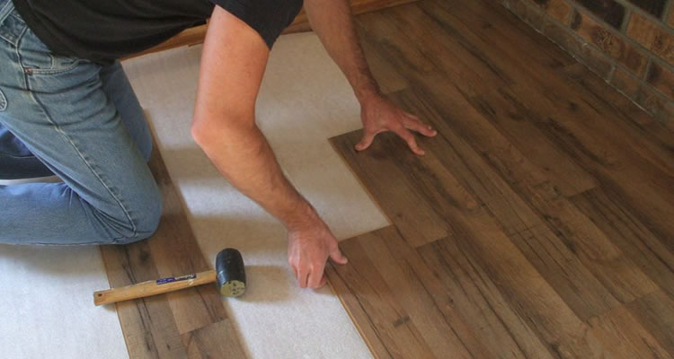 person laying laminate flooring