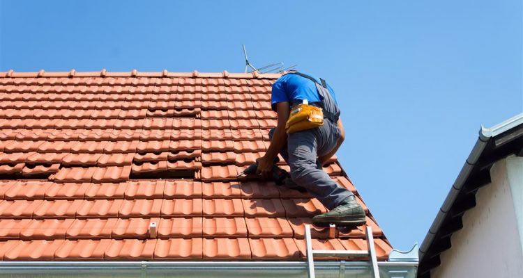 person replacing roof tiles