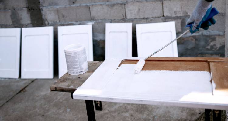 person painting kitchen cabinet doors