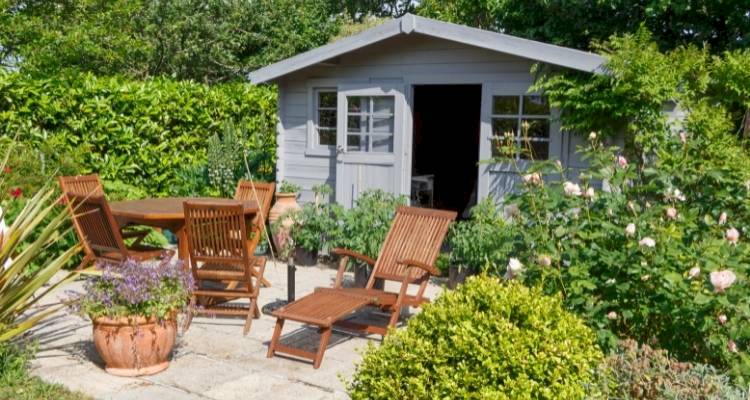 Garden shed with table and chairs and flowers around