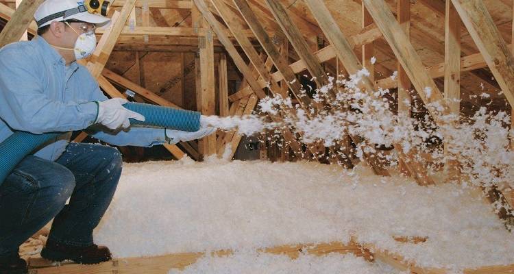 loft boarding cost guide — loose-fill insulation being installed by a specialist