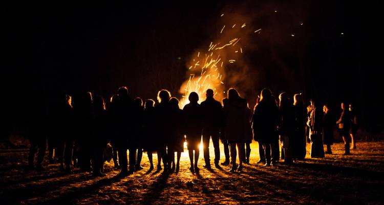 people standing around a bonfire