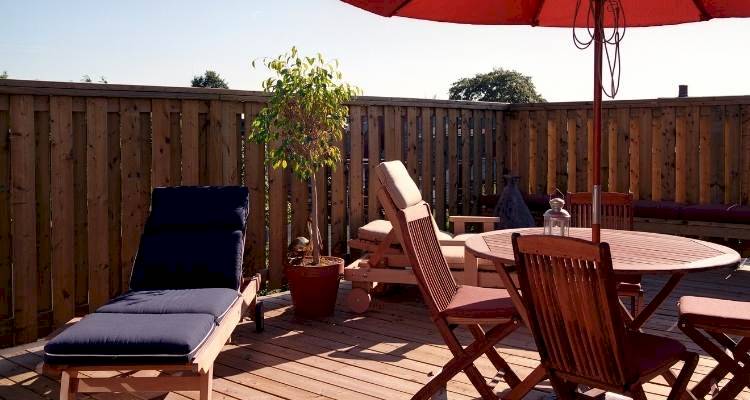 Decking area with tables and chairs and sun lounger on