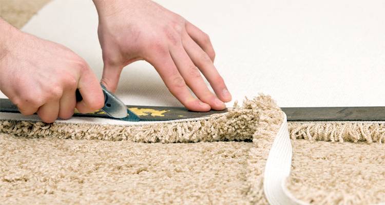 Tradesperson cutting carpet