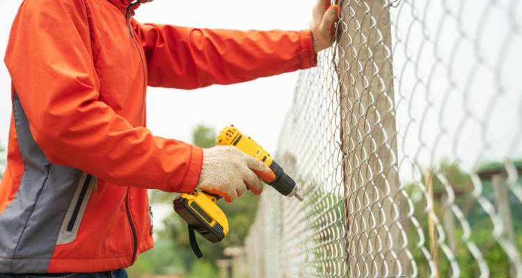 person installing chain link fenced