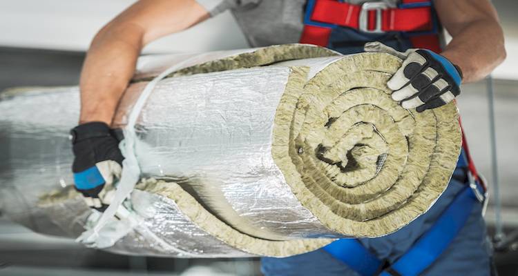 tradesperson holding a roll of insulation