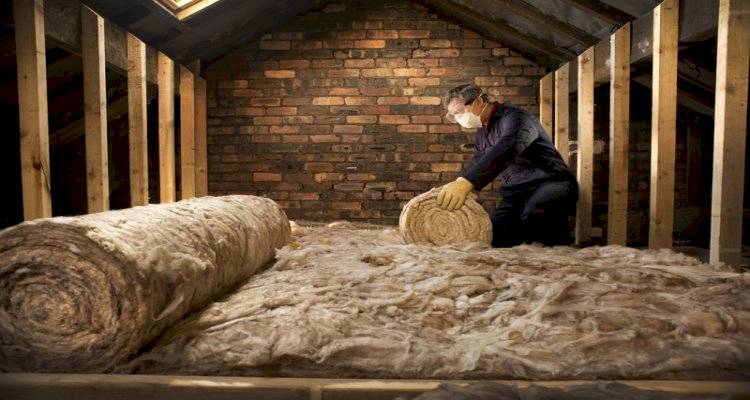 cavity wall insulation cost guide — tradesperson installing insulation in a loft