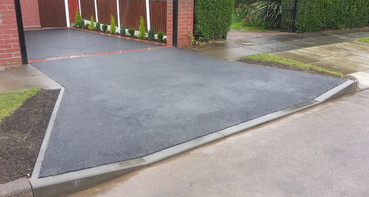 dropped kerb with a tarmac driveway