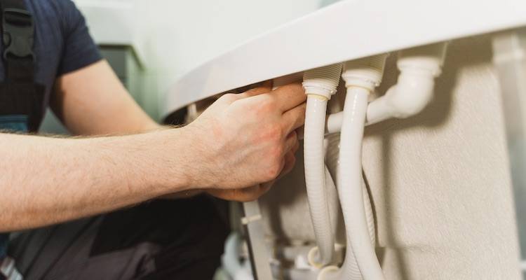 plumber installing the pipes on a bath