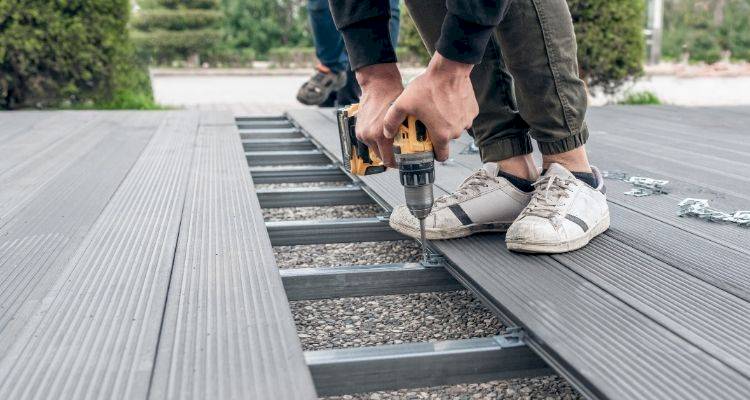 composite decking being removed by two people with drills