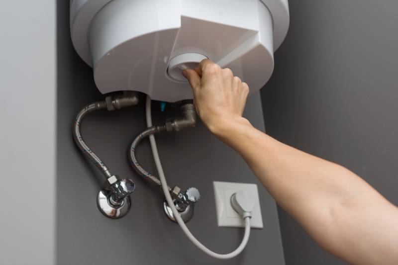 a heating engineer servicing a boiler with the front case taken off