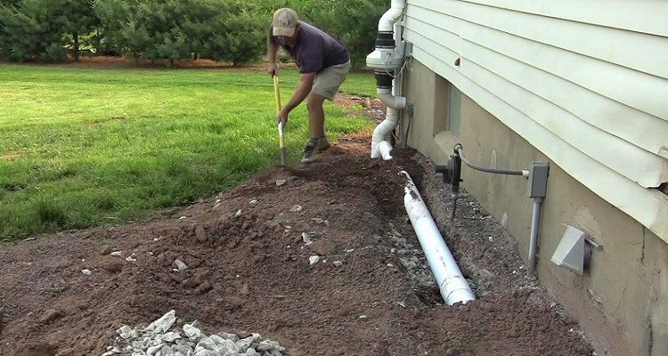 man digging to get to drain