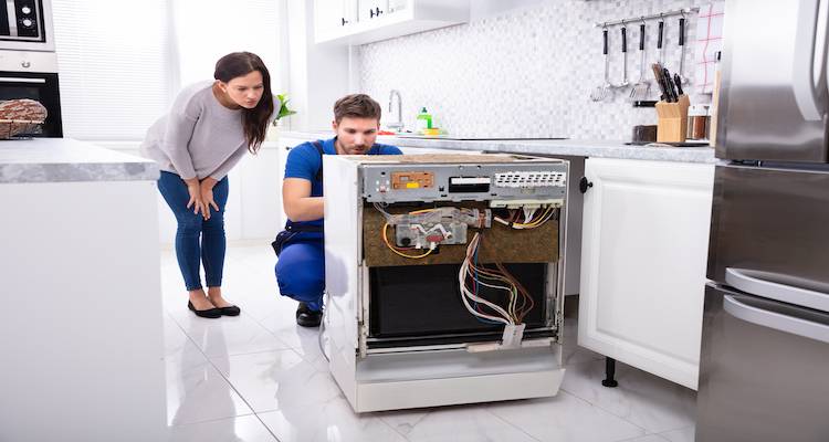 tradesperson in the process of installing a new dishwasher