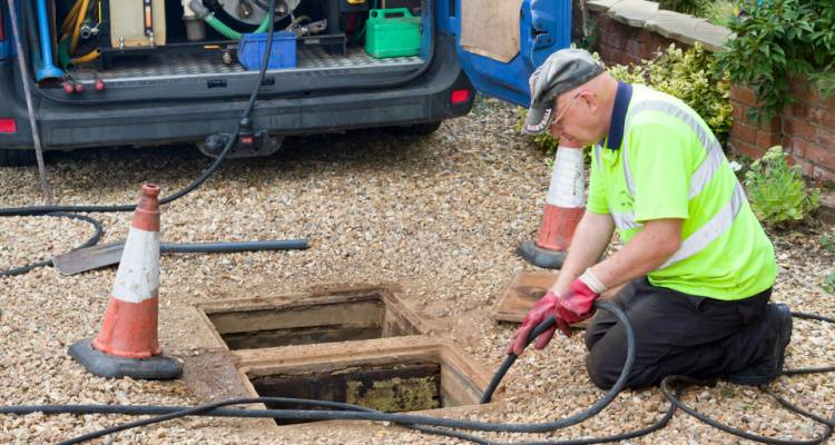 person cleaning drain