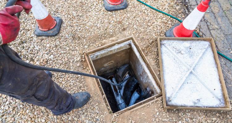 person cleaning drain