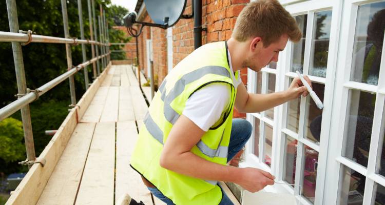 person painting window frames