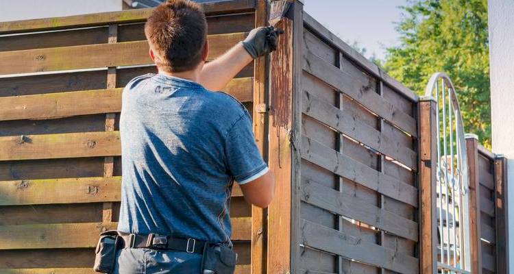 Man fixing wood fence panels