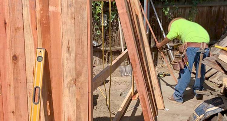 Tradesperson fixing fence panels