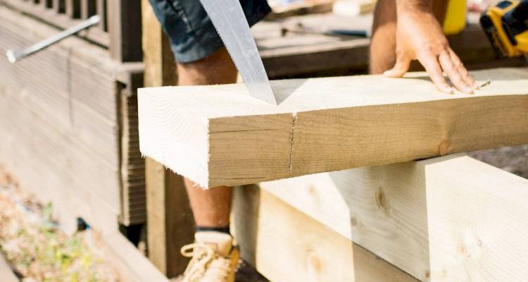 Man cutting wood fence panels