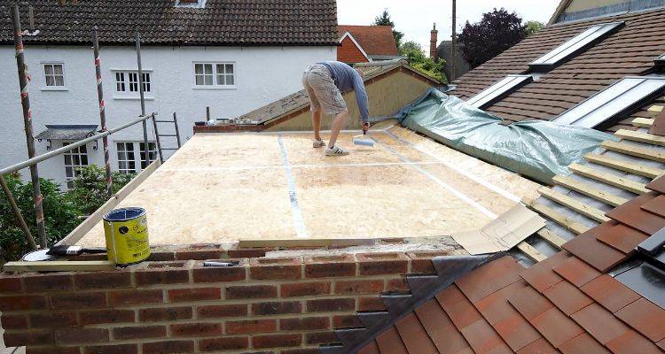person adding glue to flat roof