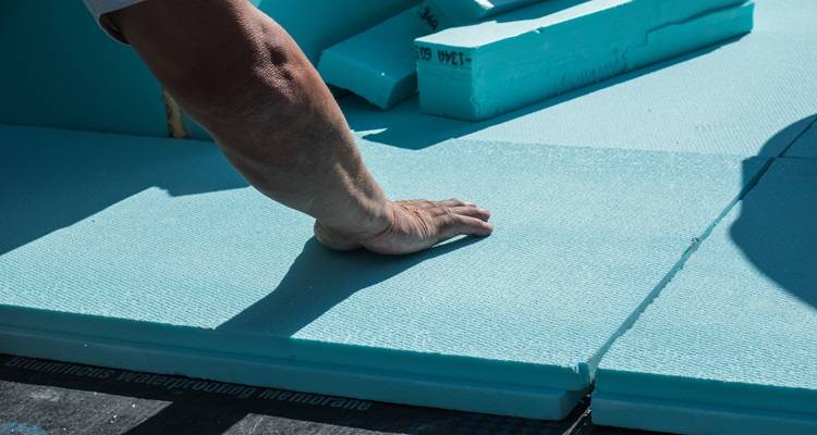 man laying roof insulation