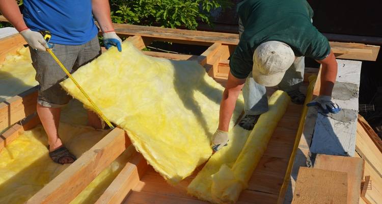 two workmen laying insulation