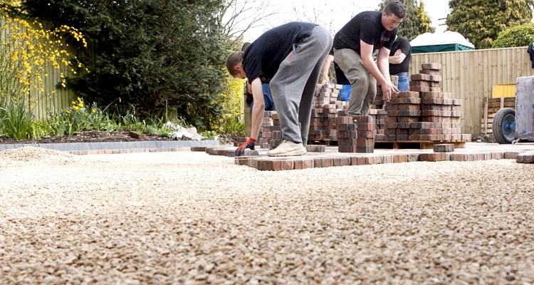A group of men installing a gravel driveway