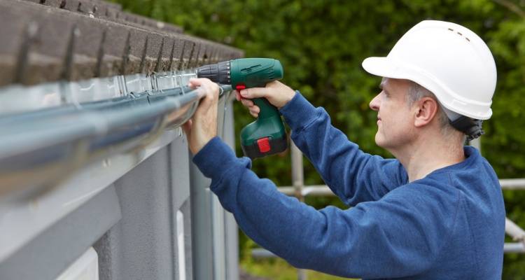 person replacing guttering