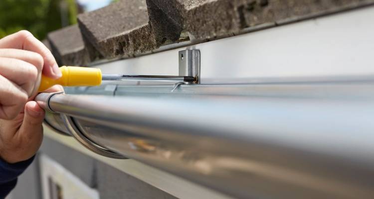 person replacing steel guttering