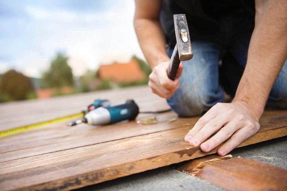 person hammering nail into wood