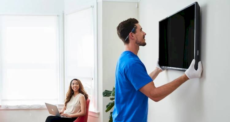 workman hanging tv lady on laptop