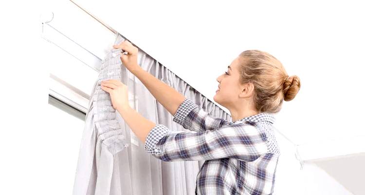 Woman hanging curtains