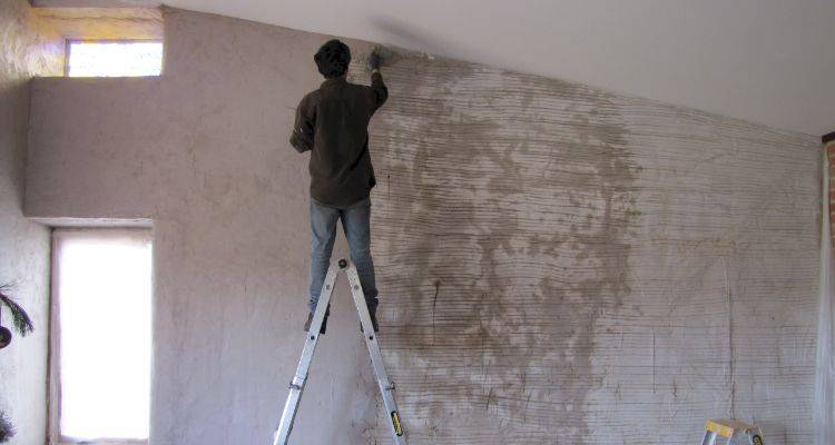 house extension cost guide — tradesperson plastering a wall