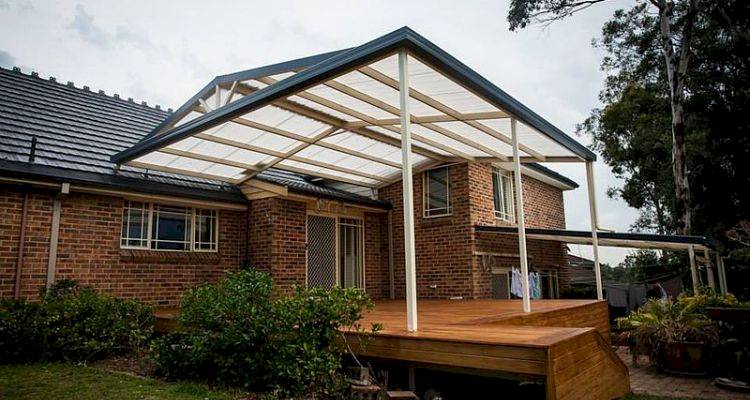 house extension cost guide — a bungalow with a custom roof that has been built over garden decking