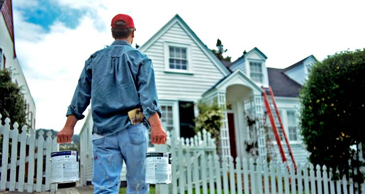 Tradeserpson walking towards house with paint