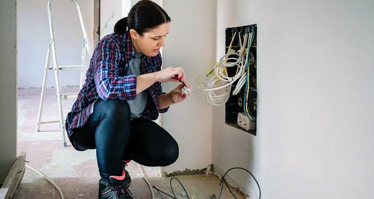 female electrician wires in wall