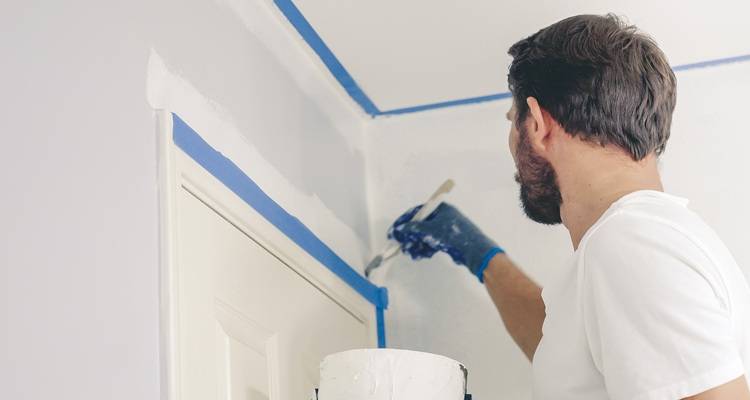 man painting blue masking tape