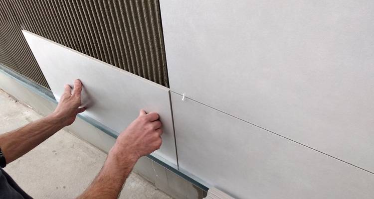 person tiling wall