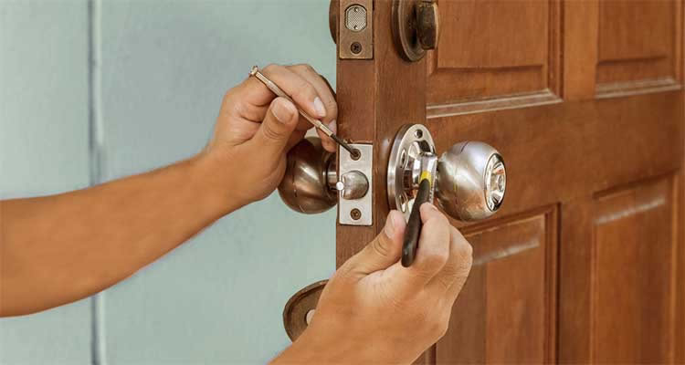 locksmith cost guide — tradesperson changing the locks on a front door