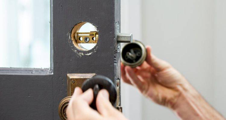 locksmith cost guide — locksmith removing the lock on a door
