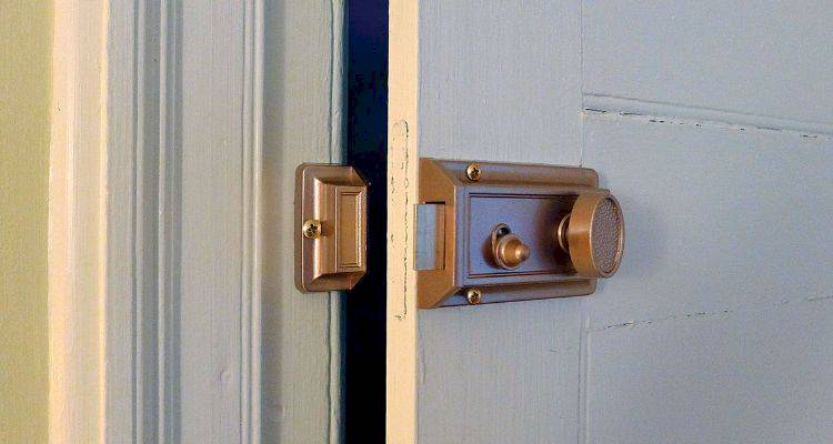 locksmith cost guide — example of a rim automatic deadlatch on a wooden door