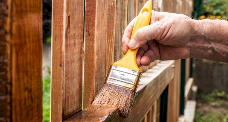 Person painting a fence