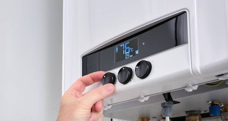 boiler installation cost guide — person using a boiler's control panel