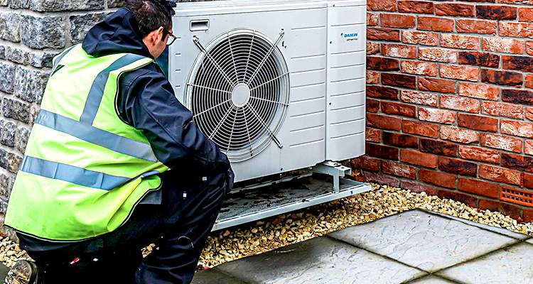 ground source heat pump cost guide — tradesperson installing heat pump