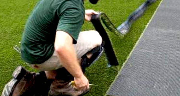 Man laying artificial grass