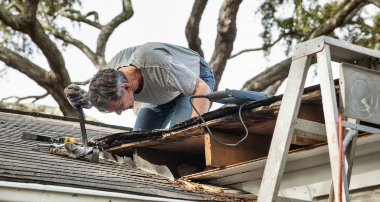 person fixing leaky roof