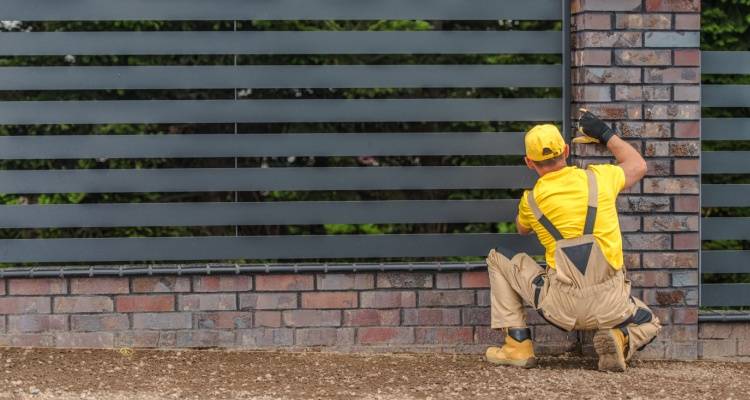 person installing metal fence