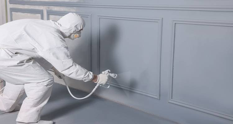 person spraying wall panels