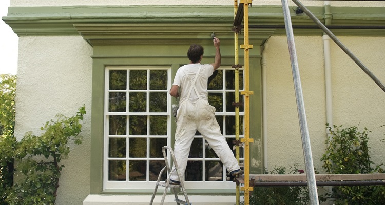 external house painter on scaffolding